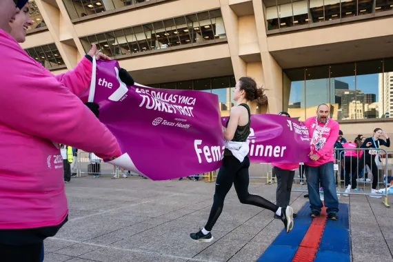 Female 8-mile course winner crossing the finish line