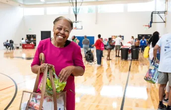 Lady smiling with a bag of goodies at the Health Expo